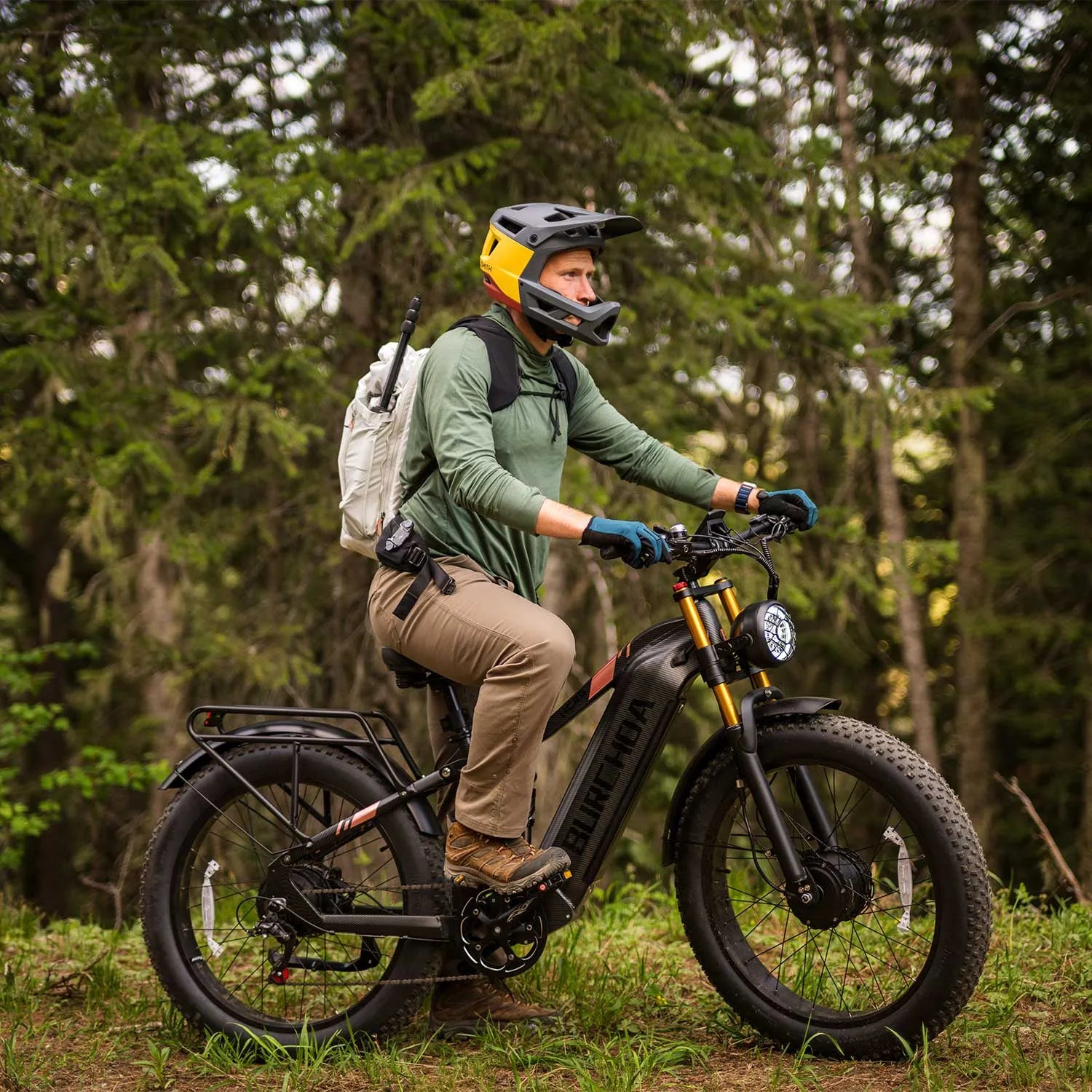 Hunter with pack on the Burchda HC26 in dense pine forest — silent approach to the stand