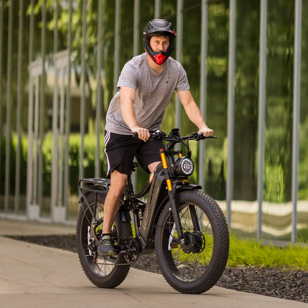A man is riding an HC26 AWD fat-tire e-bike on an outdoor trip