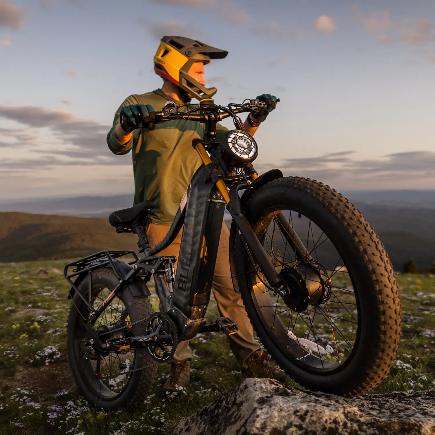 Rider standing with the Burchda HC26 AWD hunting eBike at a mountain ridge at sunset