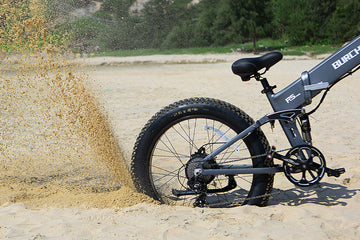 Burchda R5 Pro fat tire electric bike demonstrating its powerful 1500W hub motor by kicking up sand off-road.