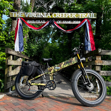 Burchda camouflage fat tire long range ebike with rear pannier bag parked at the Virginia Creeper Trail entrance